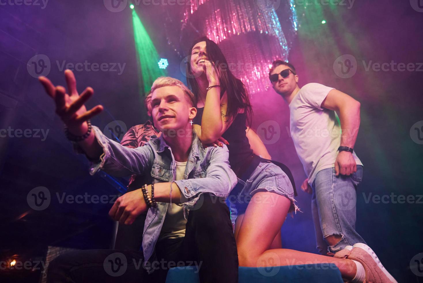 Young people is having fun in night club with colorful laser lights photo