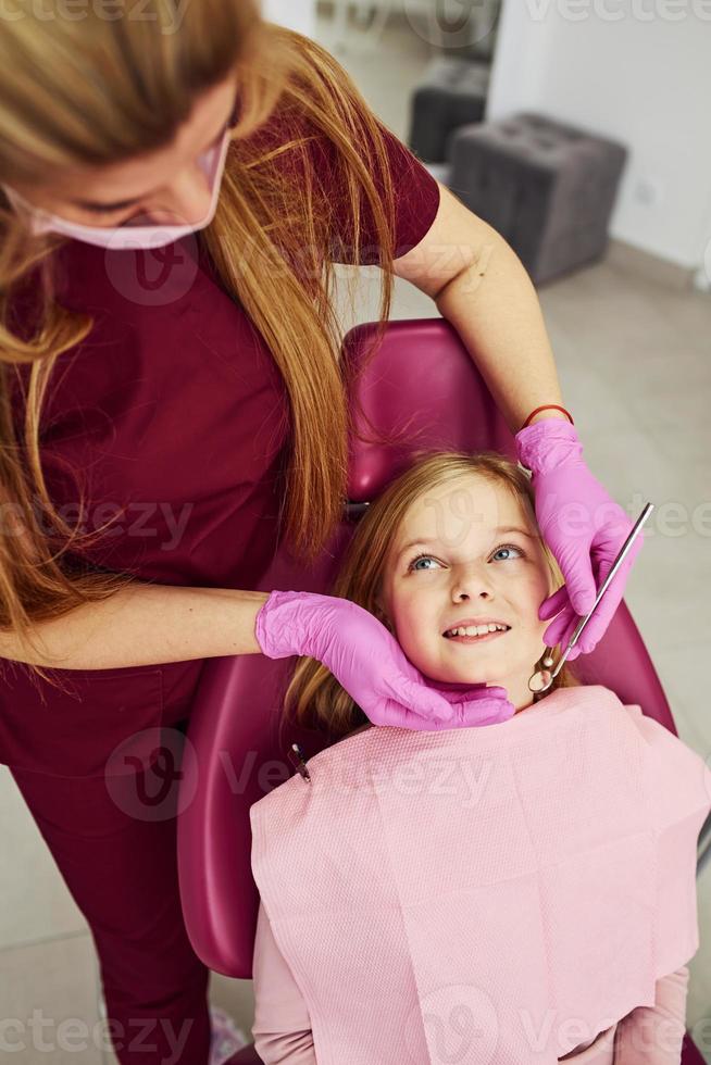 Little girl visiting dentist in clinic. Conception of stomatology photo