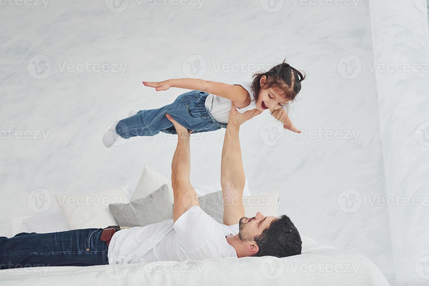 Happy father with his daughter have fun at home together photo