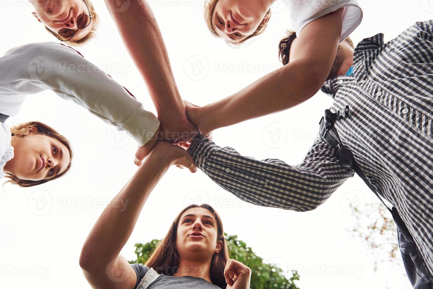 Close up view of hands of the young team of successful friends outdoors photo