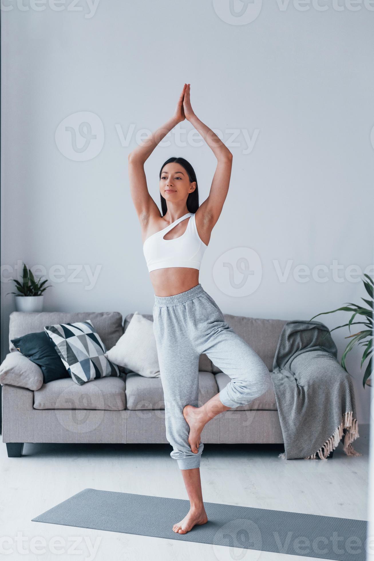 Does yoga exercises. Young woman with slim body shape in sportswear