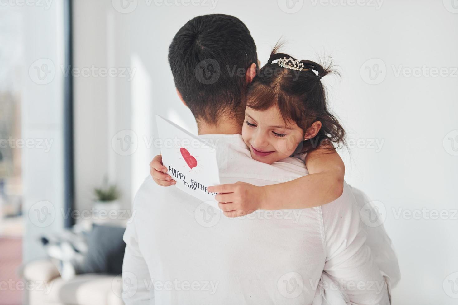 Happy father's day. Daughter makes surprise for dad by giving postcard with heart photo