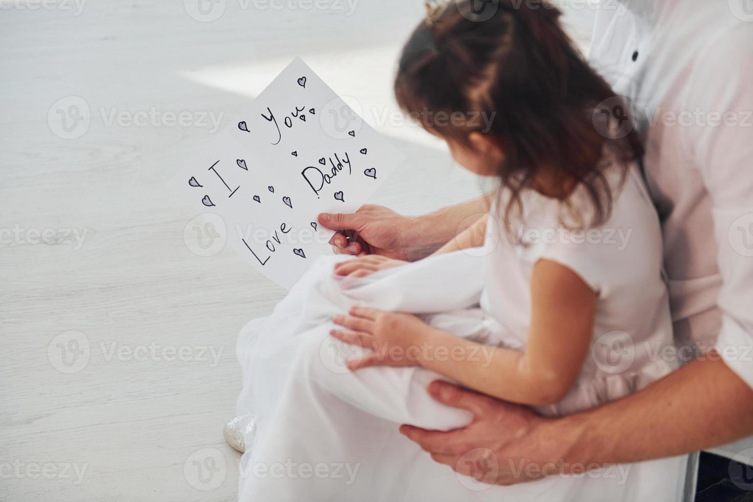 Happy father's day. Daughter makes surprise for dad by giving postcard with heart photo