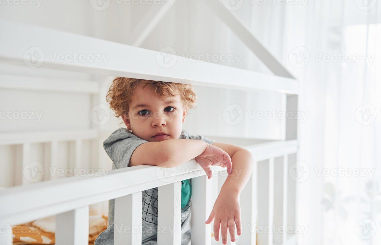 Cute little boy resting and have fun indoors in the bedroom photo