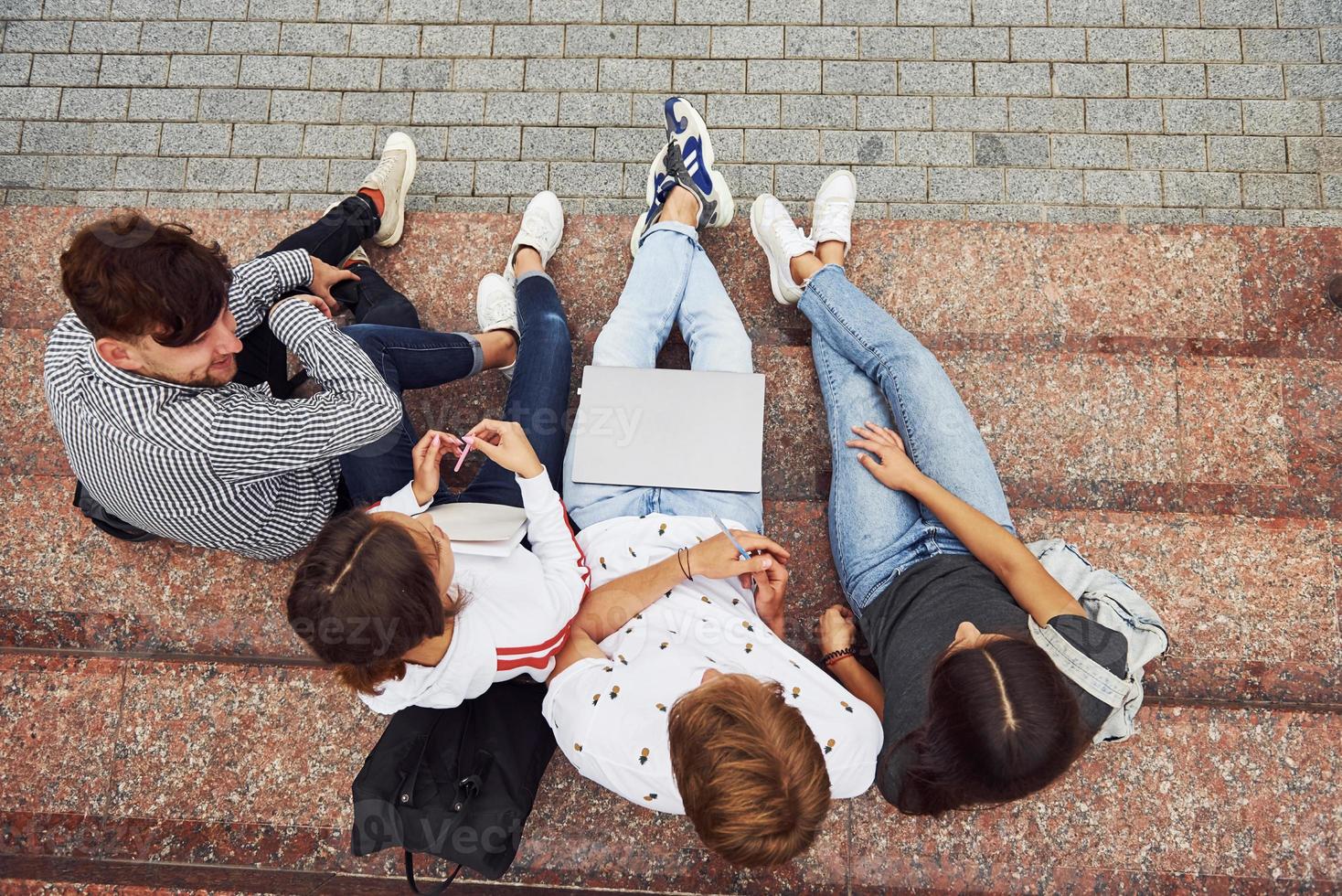 Top view. Group of young students in casual clothes near university at daytime photo