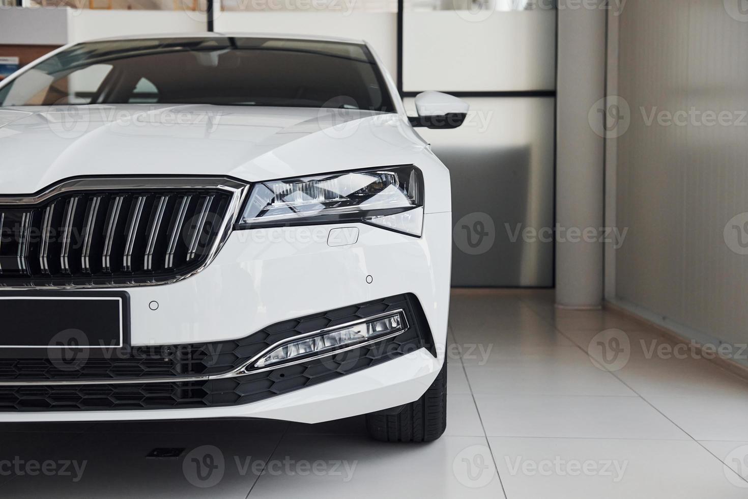 Particle view of modern brand new white car. Front part of vehicle photo