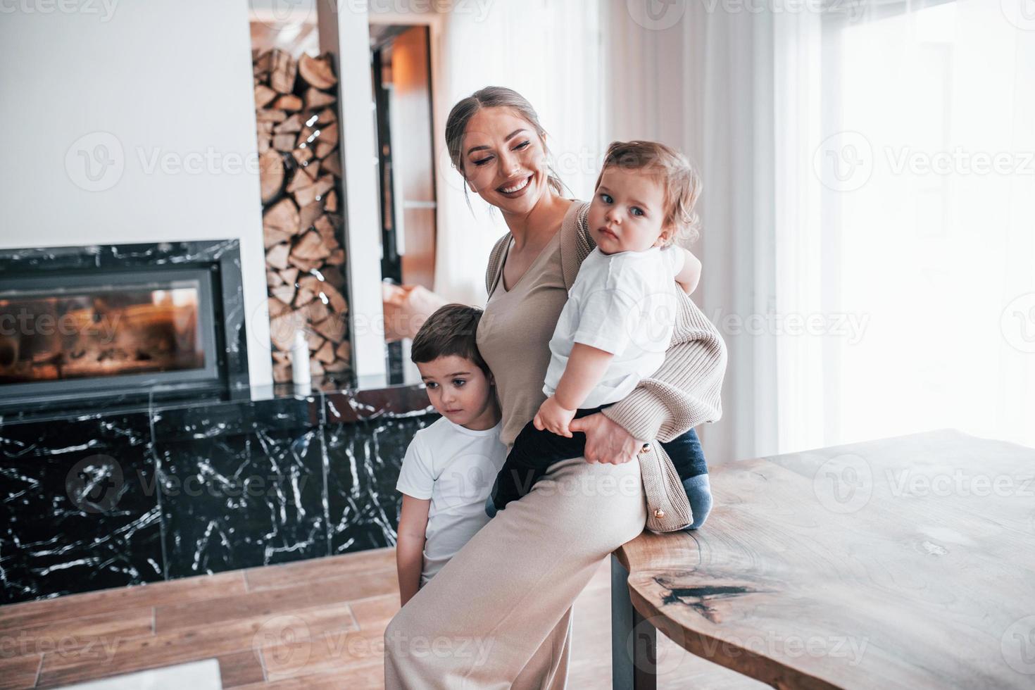 Young mother with her kids together indoors at home at weekend photo