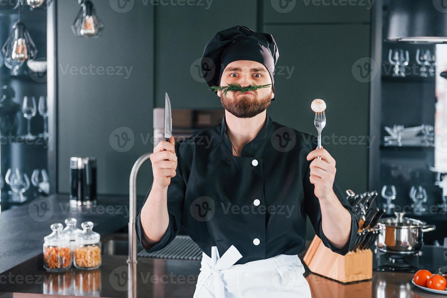 Portrait of professional young chef cook in uniform that posing for
