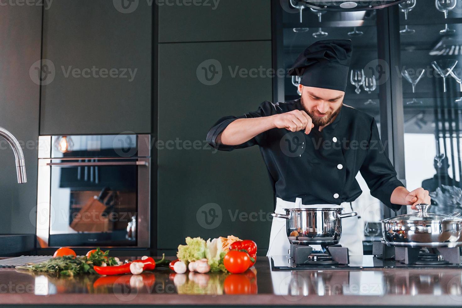 Professional young chef cook in uniform have a busy day on the kitchen photo