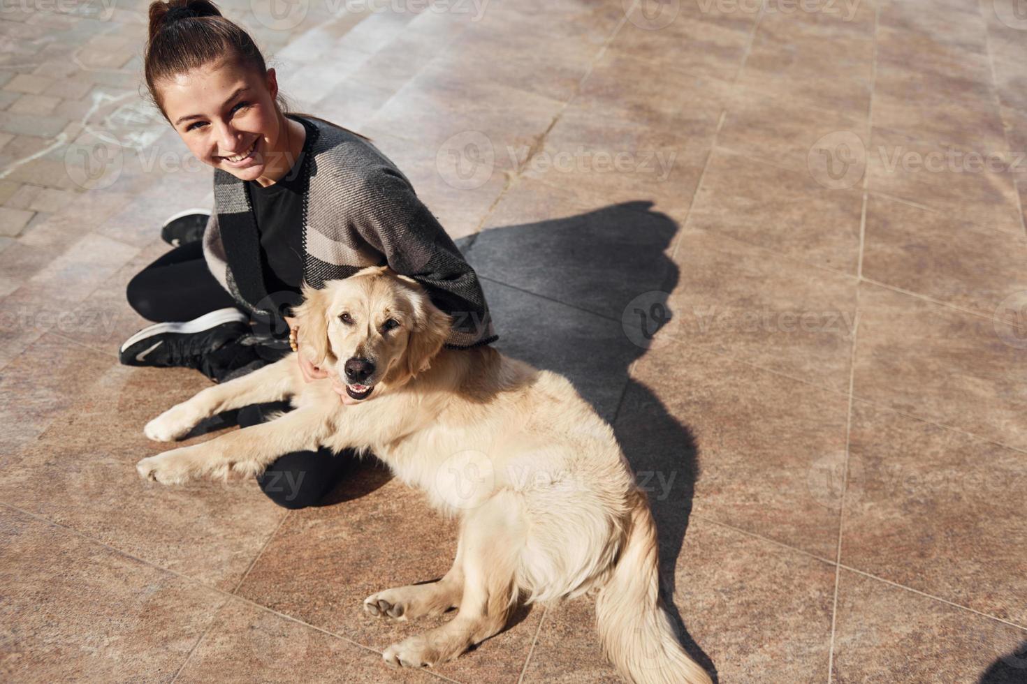 una joven positiva se divierte con su perro cuando camina al aire libre foto