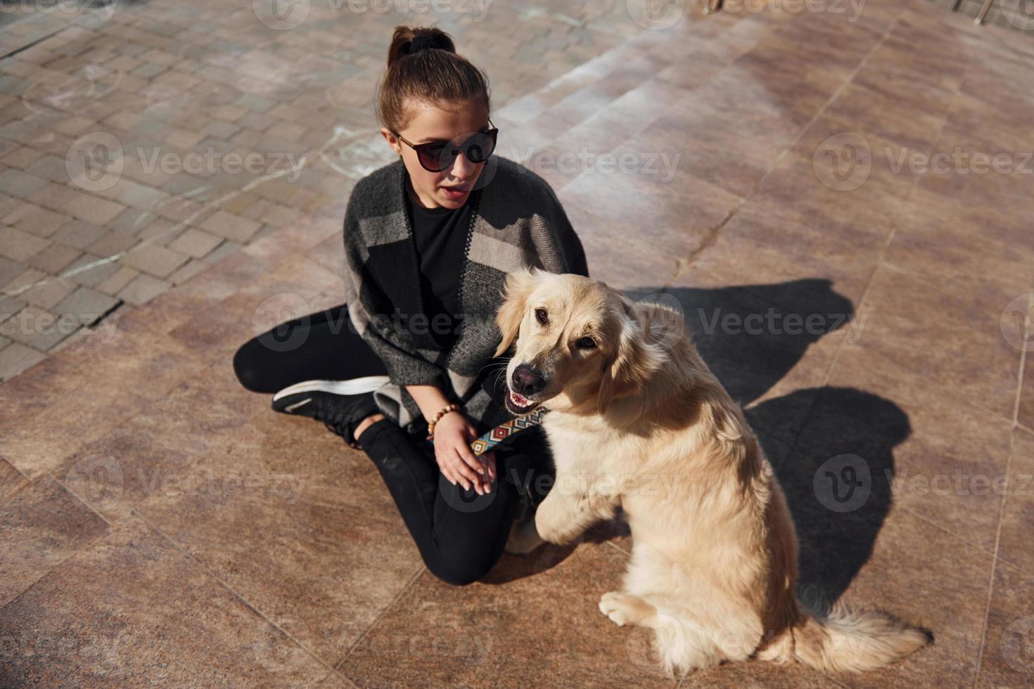 una joven positiva se divierte con su perro cuando camina al aire libre foto