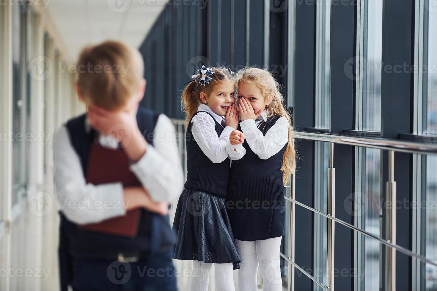 Little boy gets bullied. Conception of harassment. School kids in uniform together in corridor photo