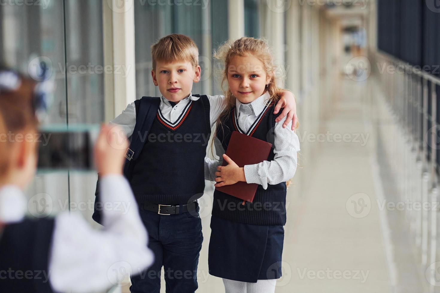 School kids in uniform making a photo together in corridor. Conception of education