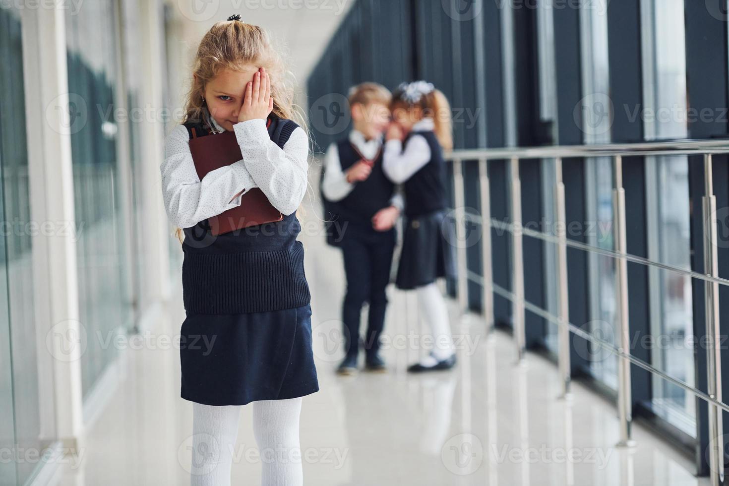 la niña es acosada. concepción del acoso. niños de la escuela en uniforme juntos en el pasillo foto