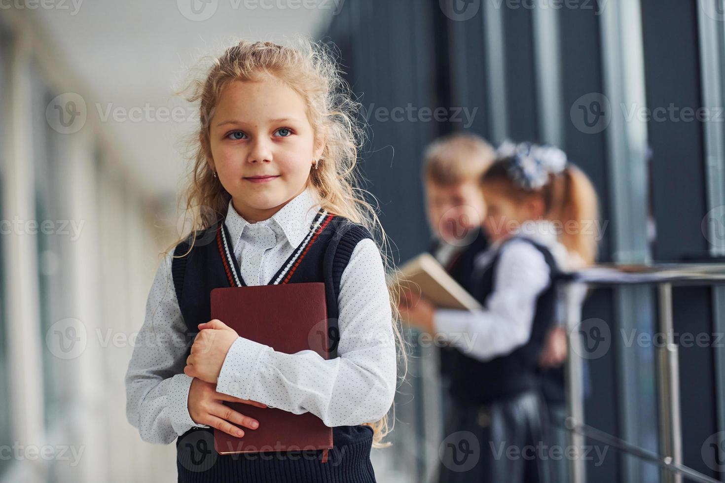 escolares en uniforme junto con libros en el pasillo. concepción de la educación foto