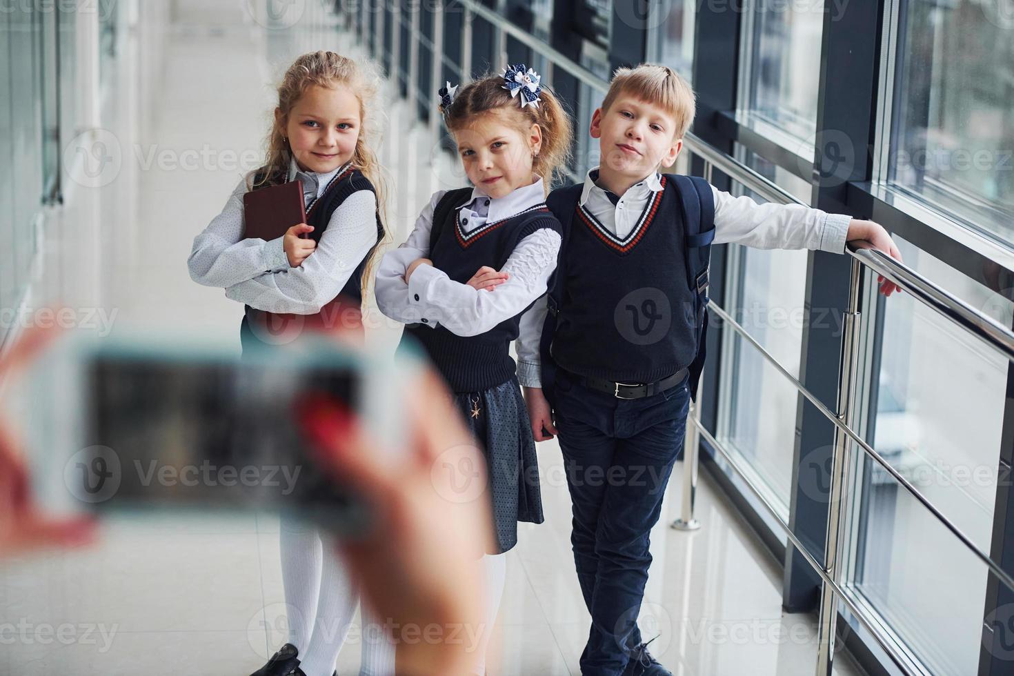 School kids in uniform making a photo together in corridor. Conception of education