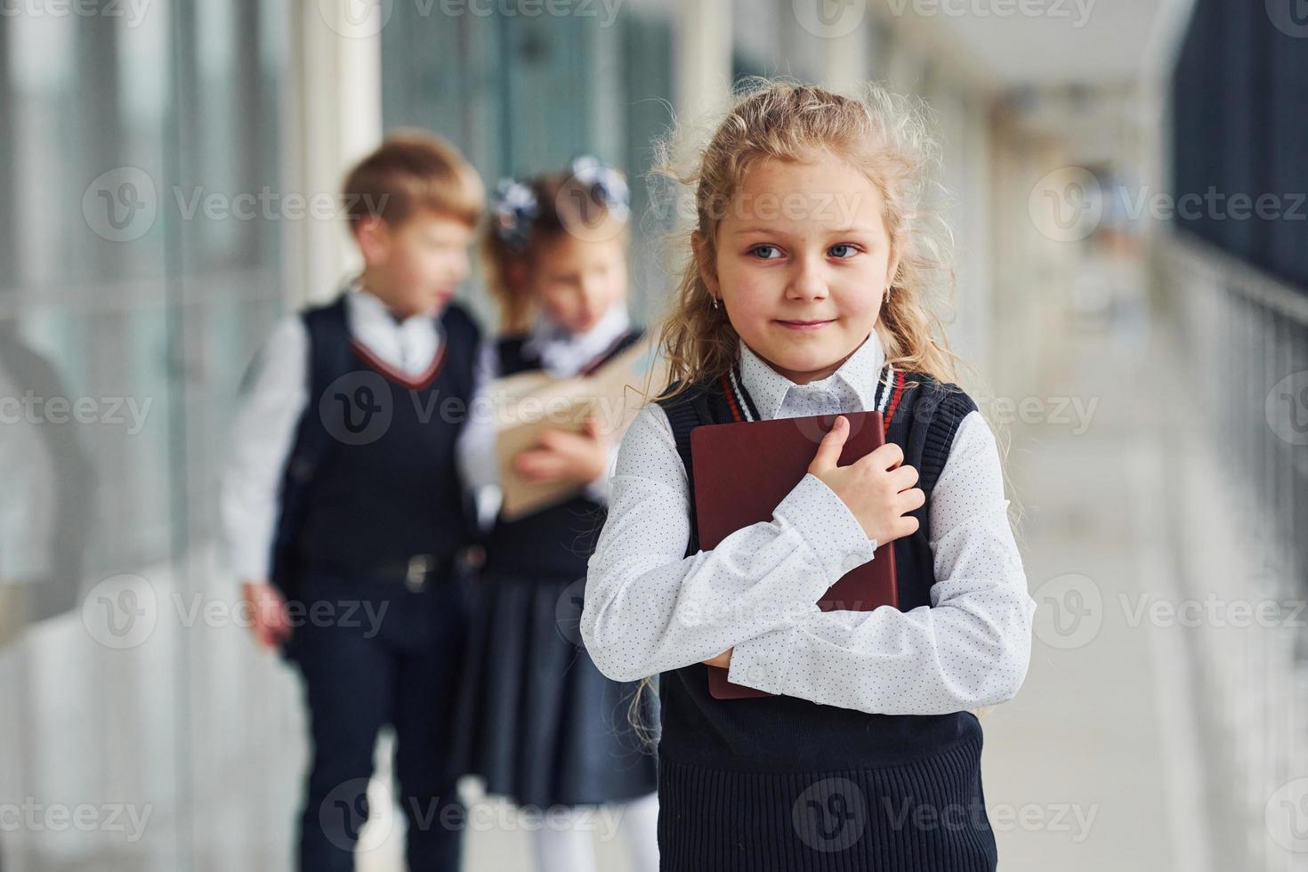 escolares en uniforme junto con libros en el pasillo. concepción de la educación foto