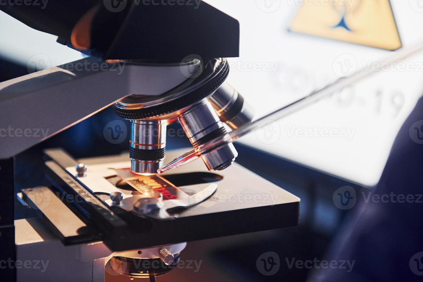 Scientist in white protective uniform works with coronavirus and blood tubes in laboratory photo