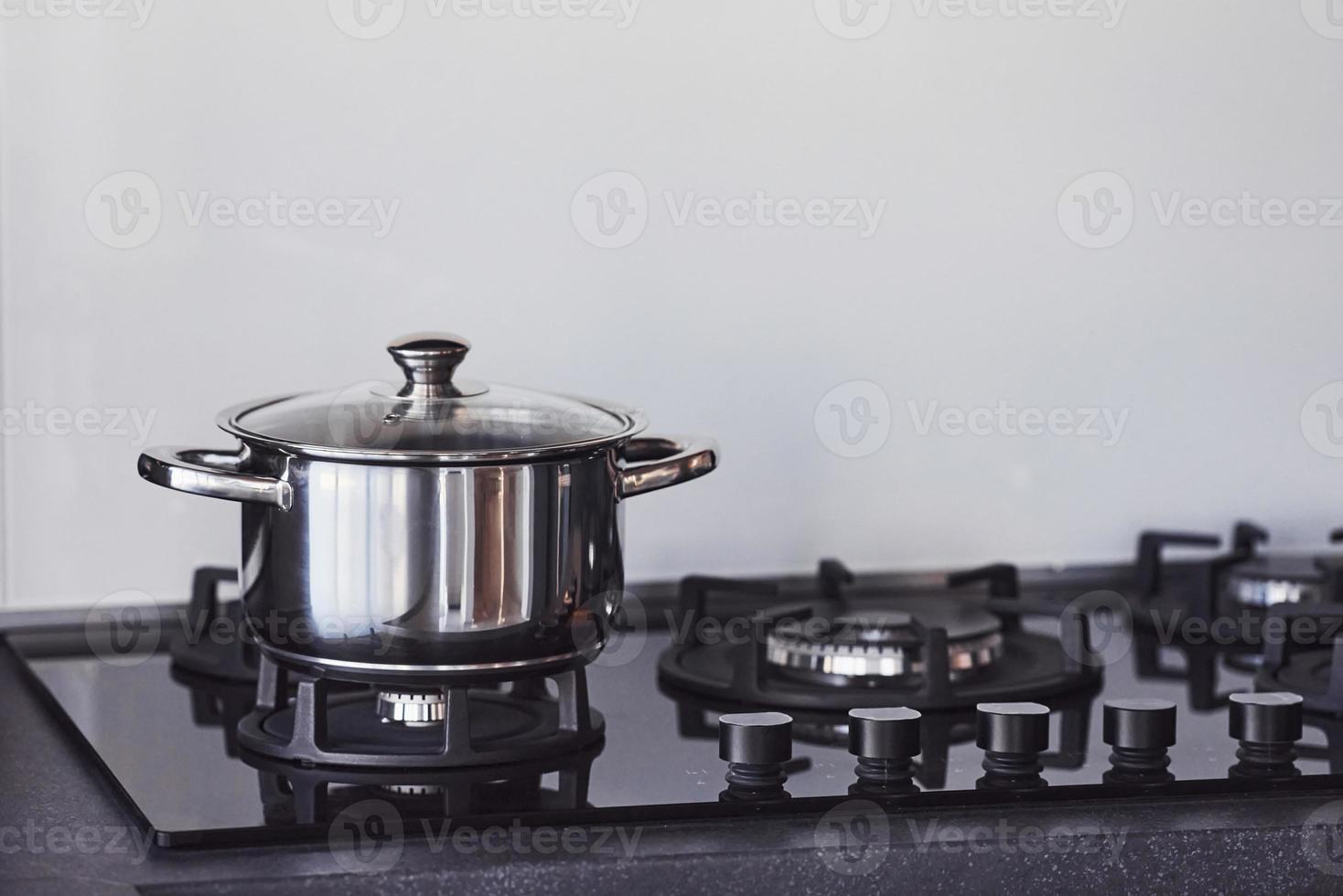 Close up view of top of a gas stove indoors near wall at daytime photo