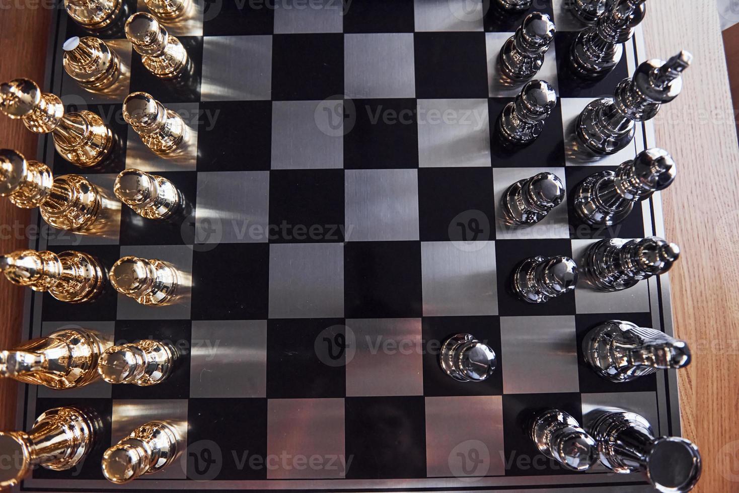 Chess board with metal figures on it indoors on the table at daytime photo
