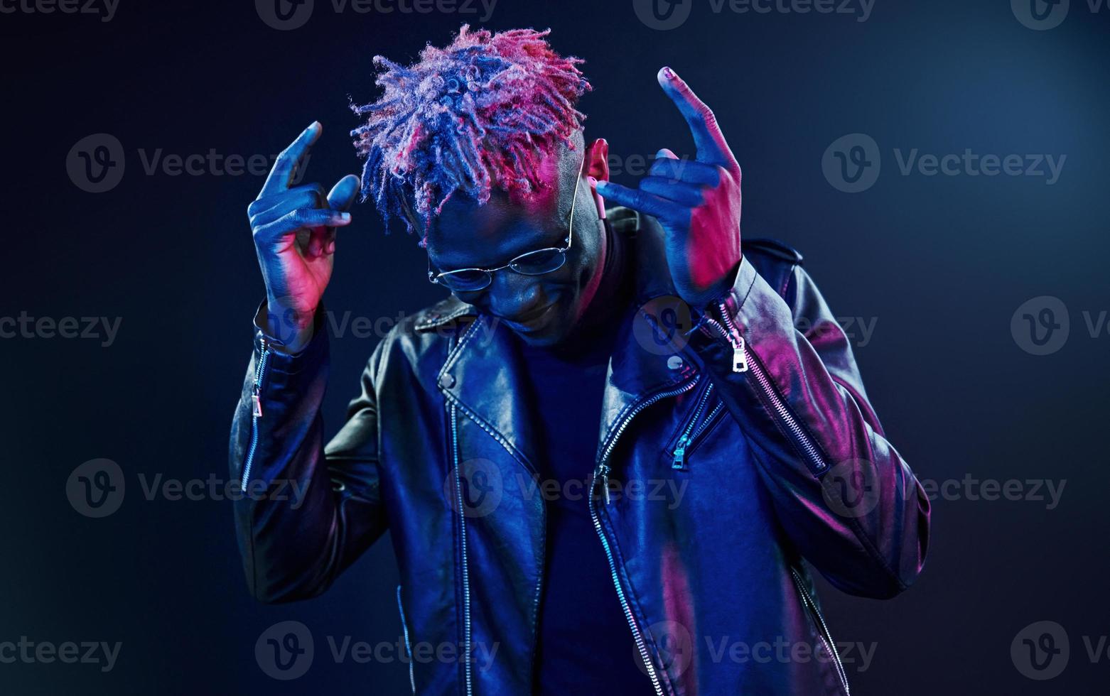 Having fun. Futuristic neon lighting. Young african american man in the studio photo