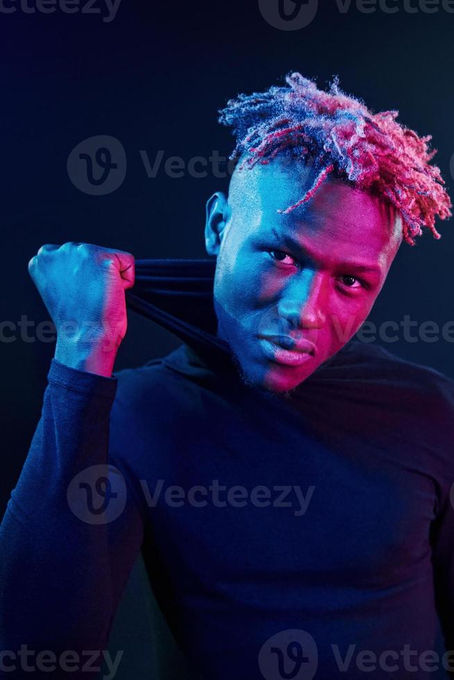 Futuristic neon lighting. Young african american man in the studio photo