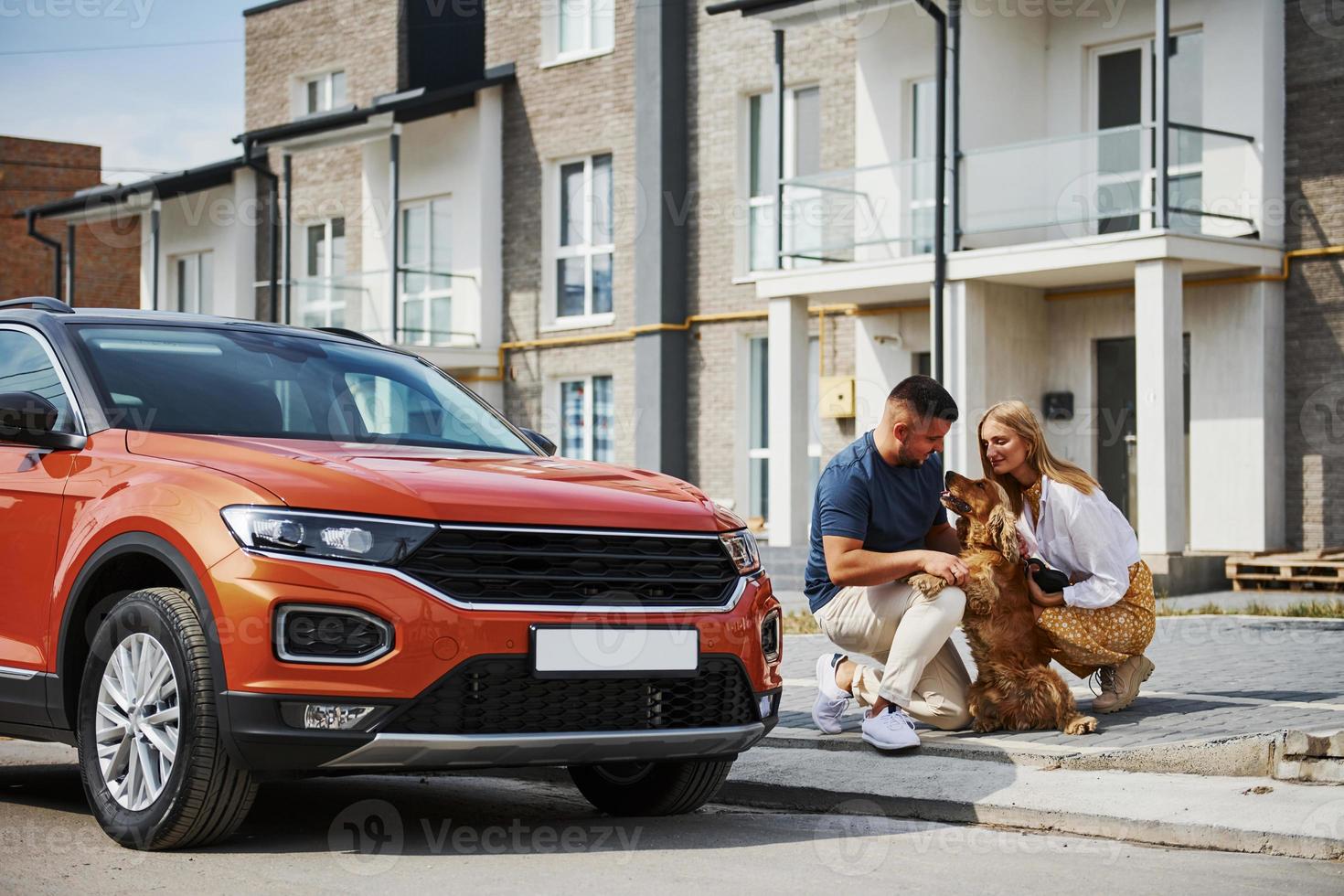 Lovely couple have a walk together with dog outdoors near the car photo