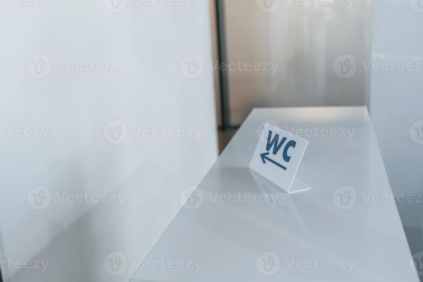 firmar con palabras de wc que muestren la dirección al baño en el interior foto