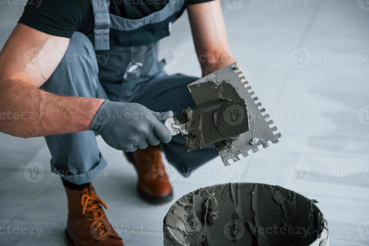 Man in grey uniform works with plate indoors in modern big office at daytime photo