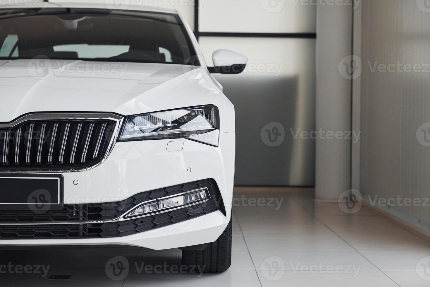 Particle view of modern brand new white car. Front part of vehicle photo