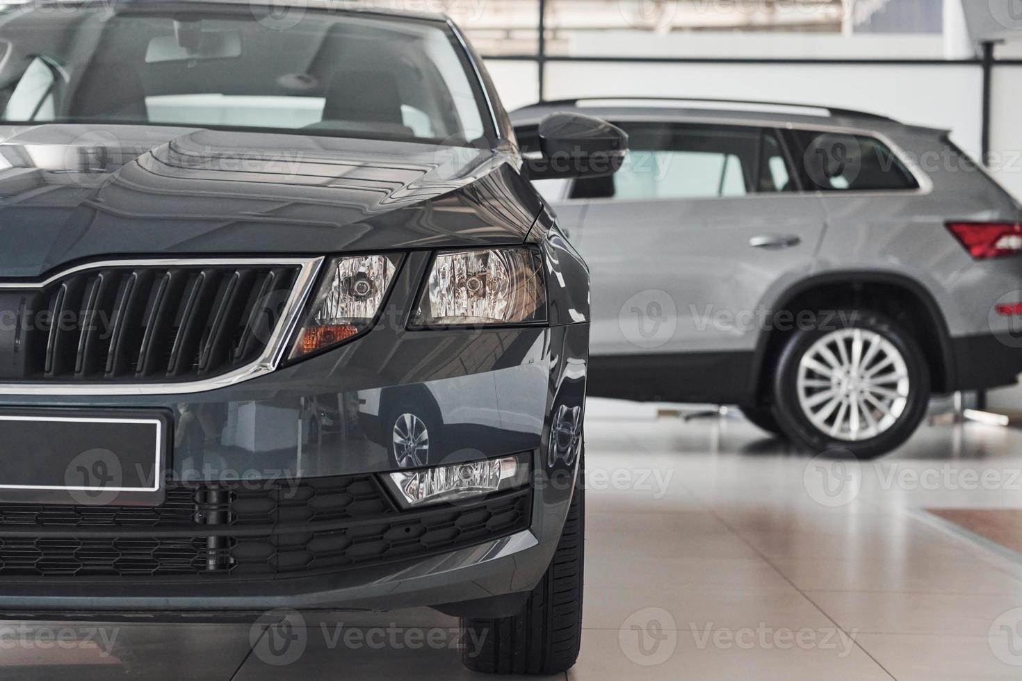 Particle view of modern brand new black and silver cars. Front and side part of vehicles photo