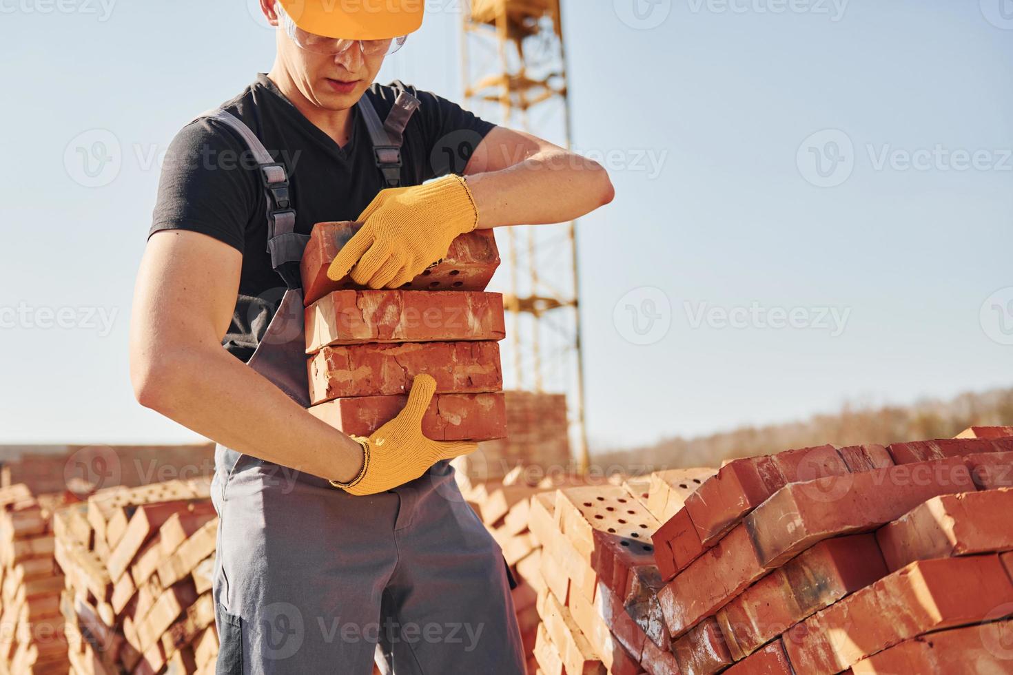 Installing brick wall. Construction worker in uniform and safety equipment have job on building photo