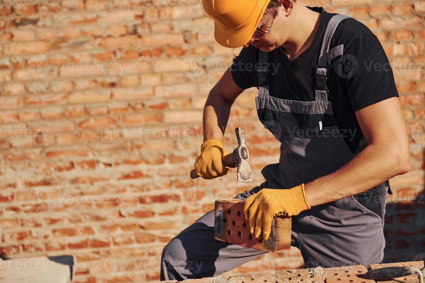 Construction worker in uniform and safety equipment have job on building photo