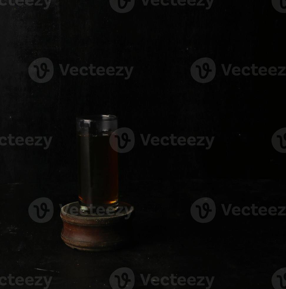 Glass cup of tea on black background photo