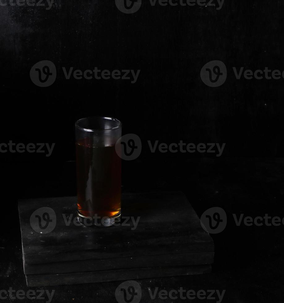 Glass cup of tea on black background photo
