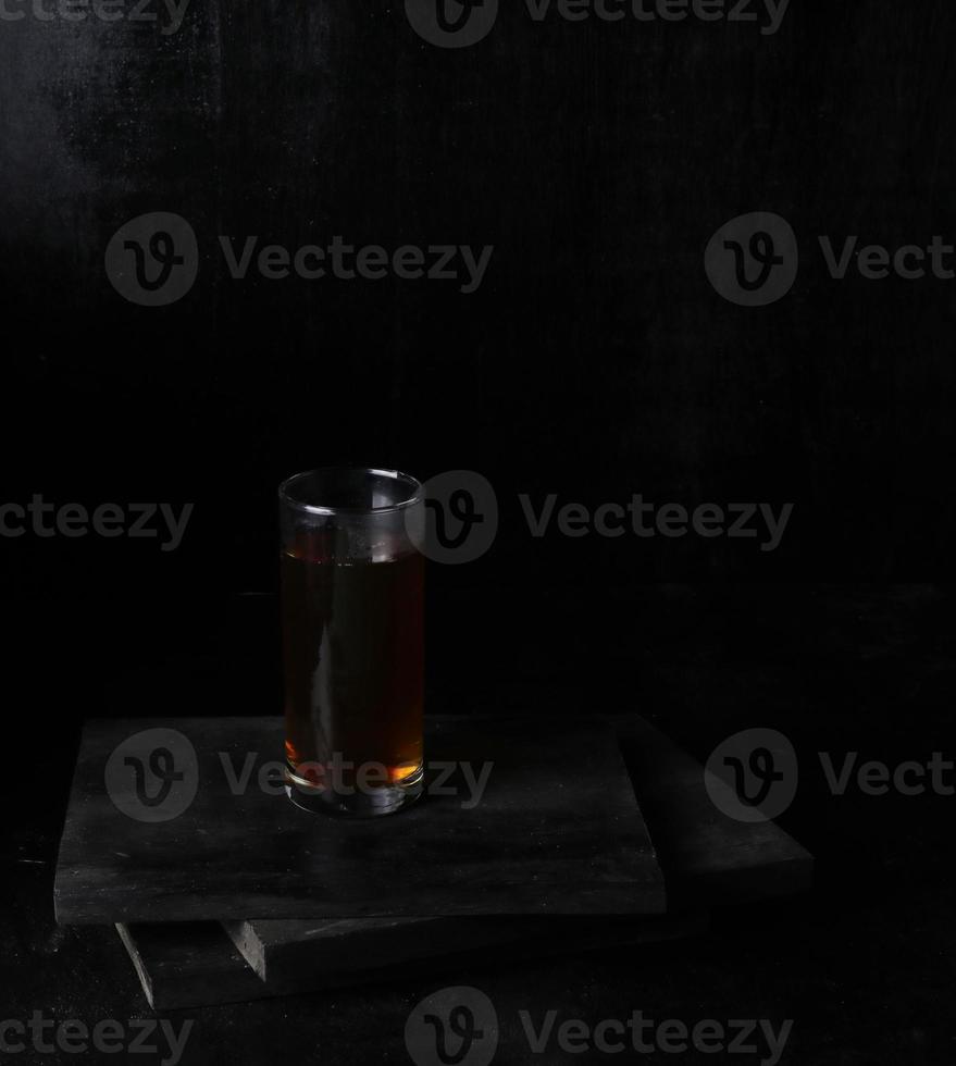 Glass cup of tea on black background photo