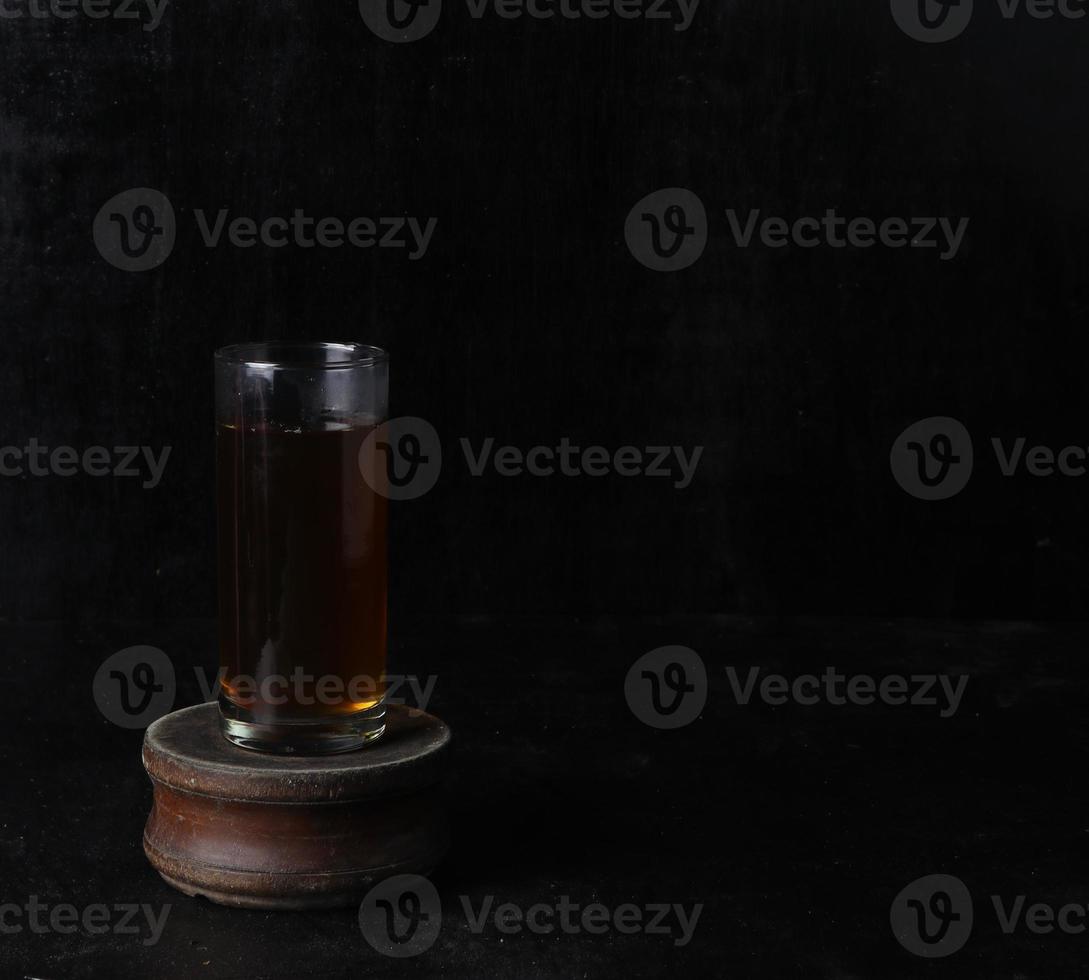 Glass cup of tea on black background photo