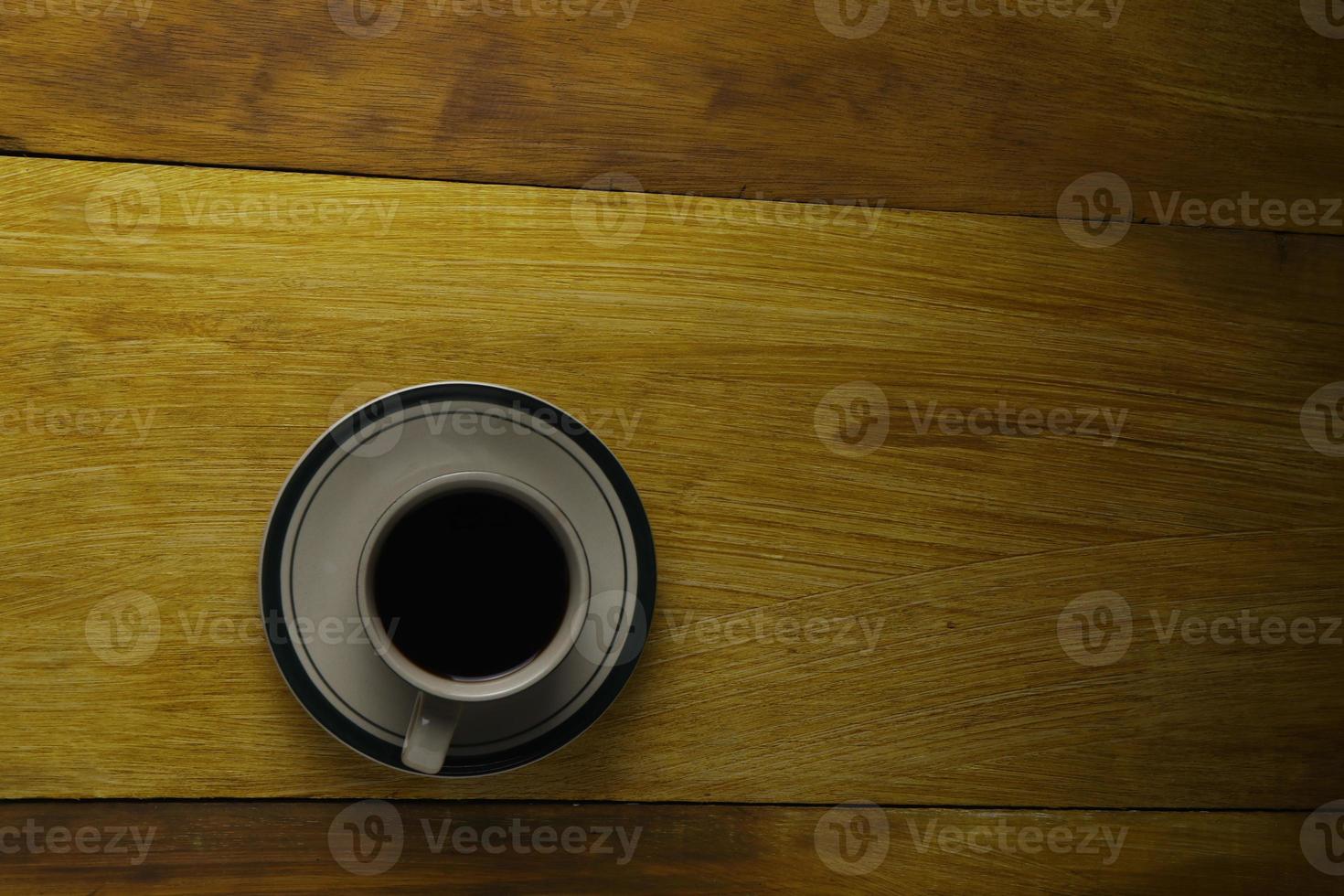 taza de café negro sobre un fondo de madera. área de espacio de copia foto