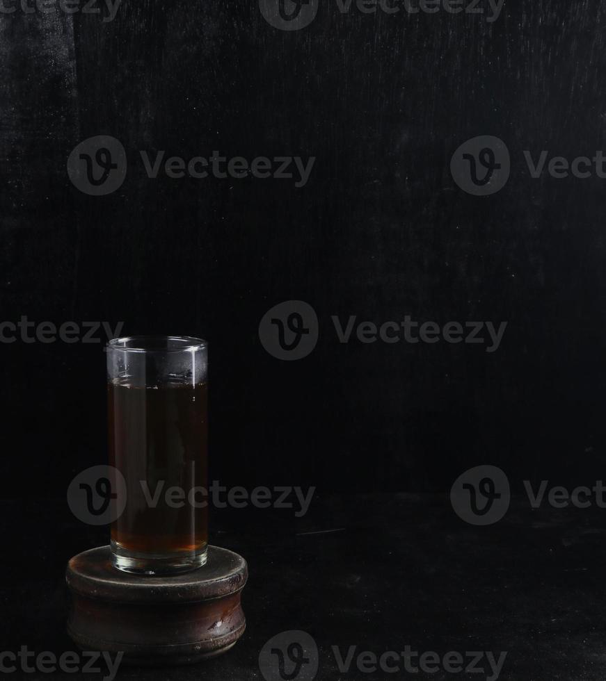 Glass cup of tea on black background photo
