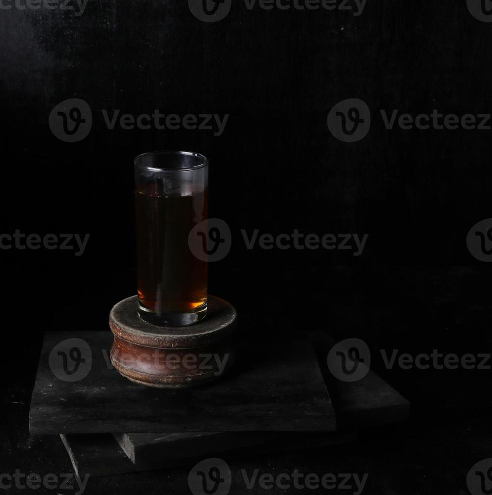 Glass cup of tea on black background photo