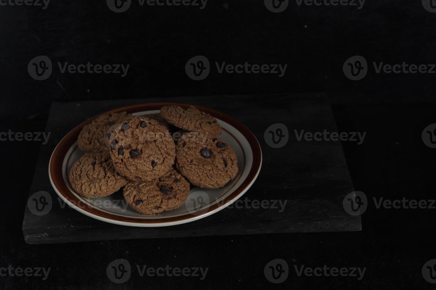 Chocolate chip cookies on plate on black background photo