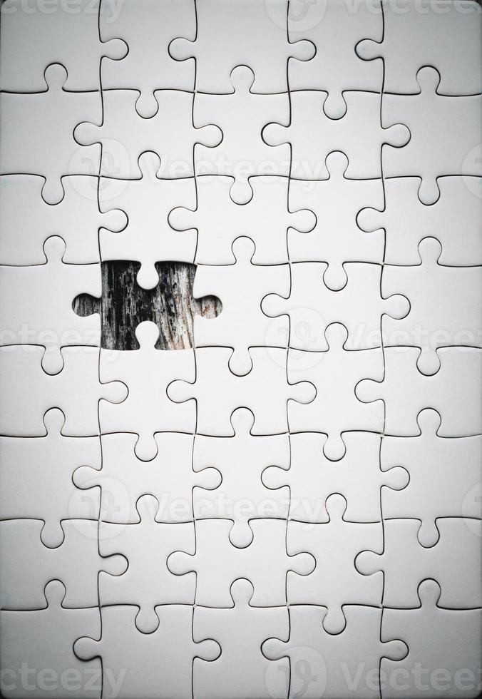 White details of jigsaw puzzle piece on wooden background. Concept of working together as a business team. The idea of getting involved, working for success. photo