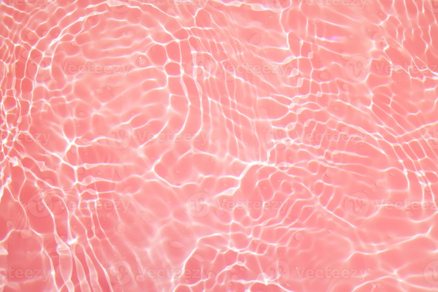 Defocus blurred transparent pink colored clear calm water surface texture with splashes and bubbles. Trendy abstract nature background. Water waves in sunlight with copy space. Pink watercolor shining photo