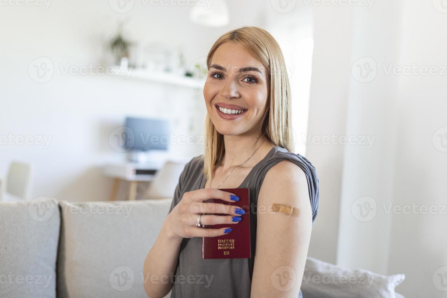 Young woman with adhesive bandage on her arm after Corona virus covid 19 vaccine holding her passport. ready to travel. First aid. Medical, pharmacy and healthcare concept. photo