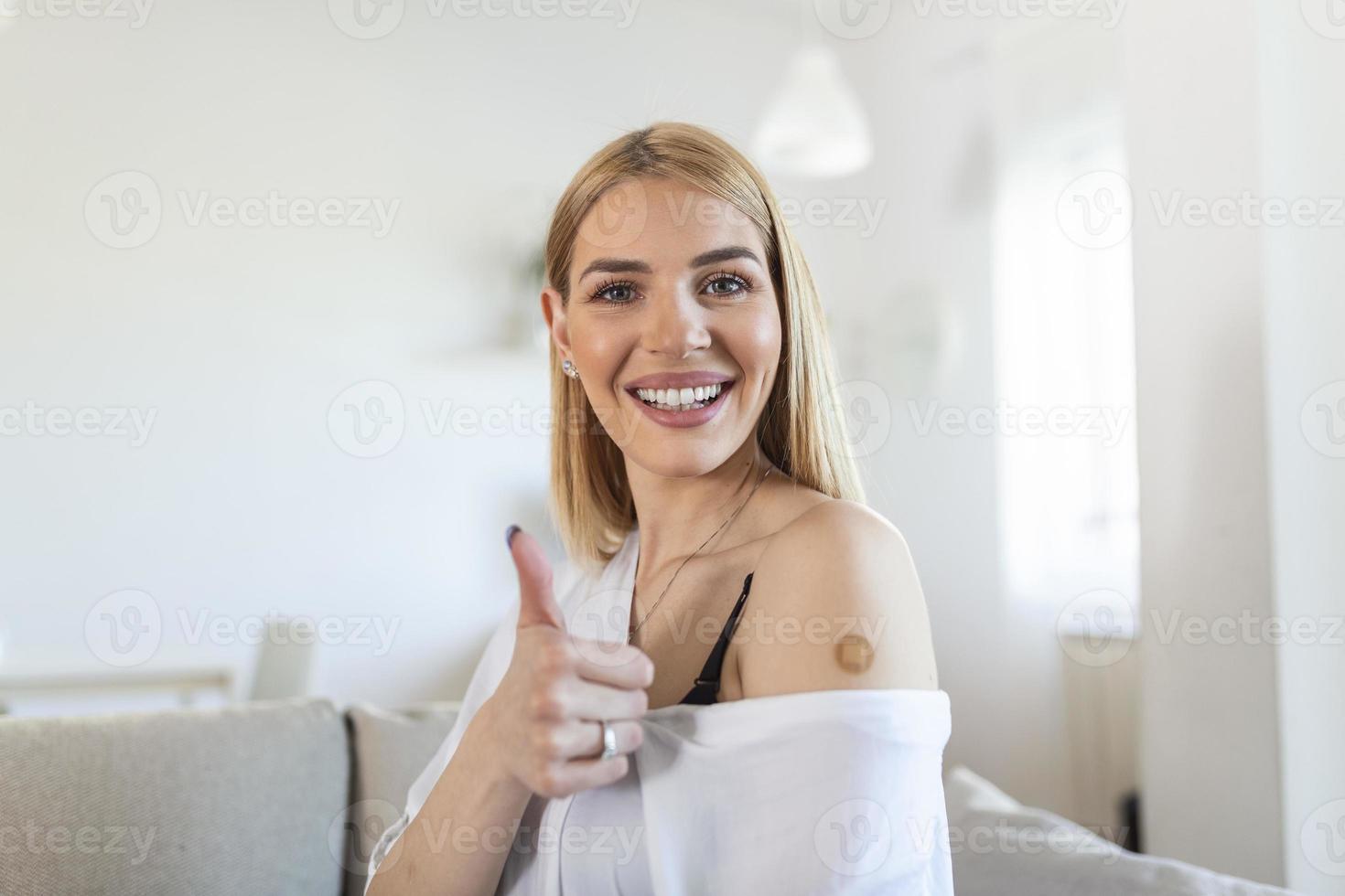 Vaccinated young Woman Gesturing Thumbs-Up Approving Vaccination, home Background photo