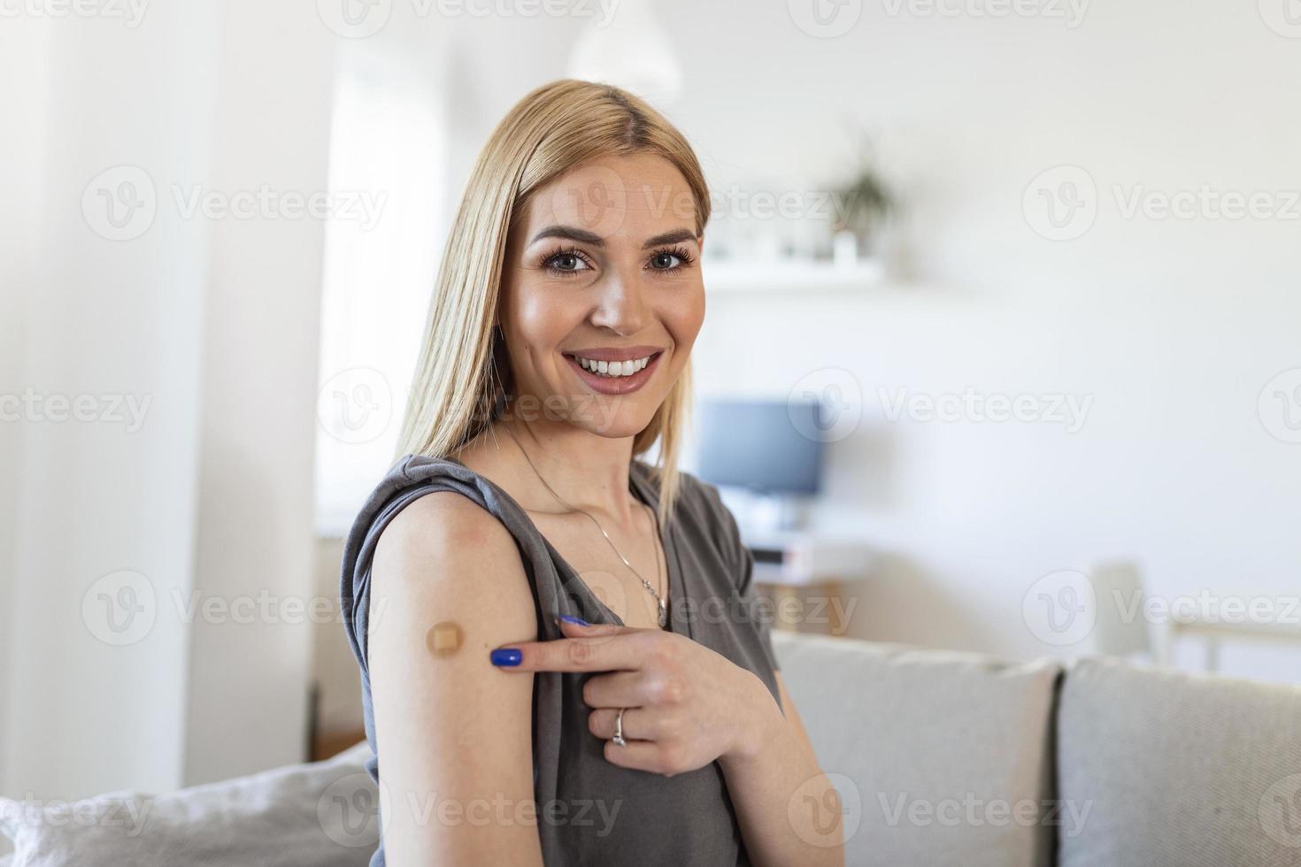 mujer joven con venda adhesiva en el brazo después de la vacuna contra el virus de la corona. primeros auxilios. concepto médico, farmacéutico y sanitario. foto