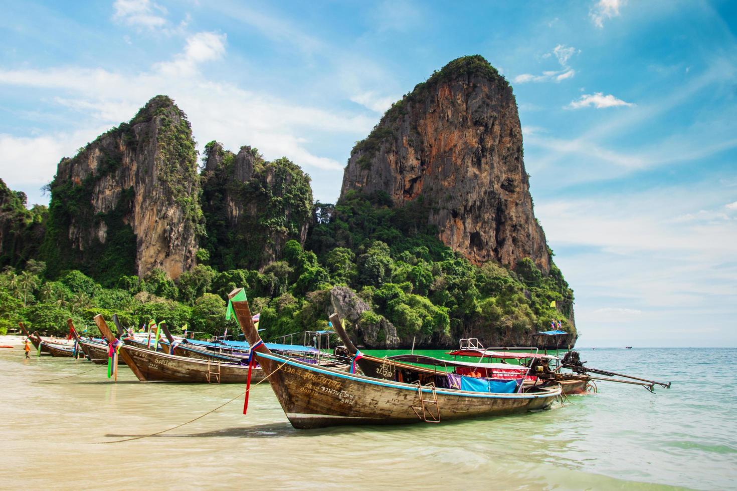 krabi, tailandia - 5 de abril de 2017. vista de una costa con botes de cola larga en la playa de railay. foto