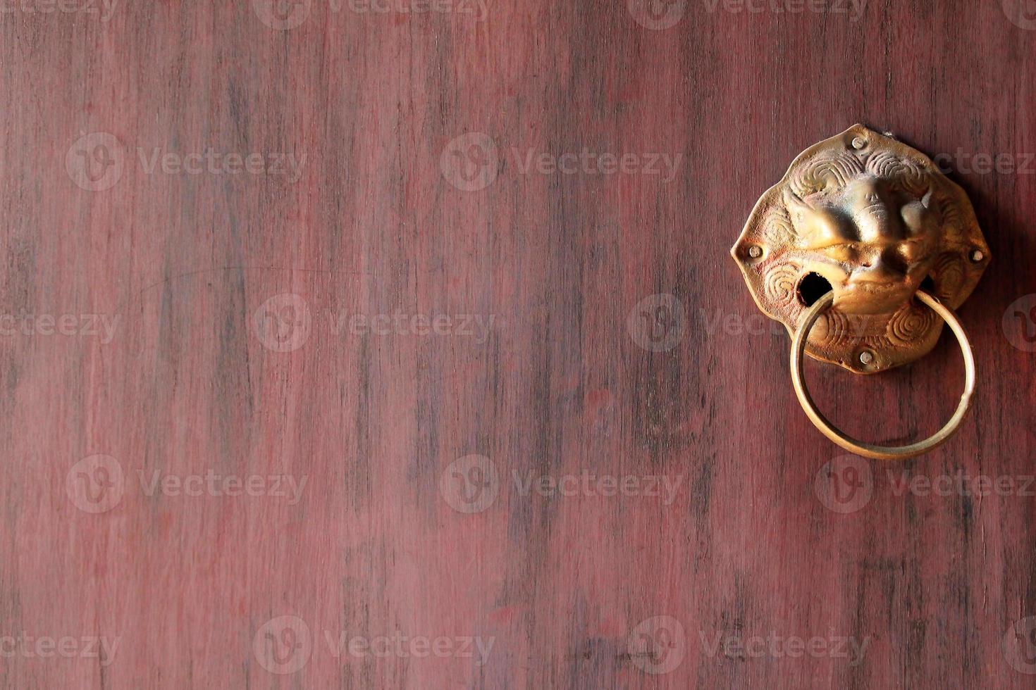 Fragment of the wooden painted door with ancient brass door knob. Chiangmai, Thailand. photo