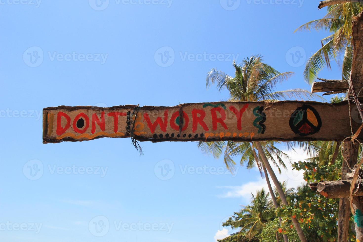 koh lanta, tailandia. una inscripción - no te preocupes - en la cabaña de madera abandonada sobre un fondo de cielo. foto