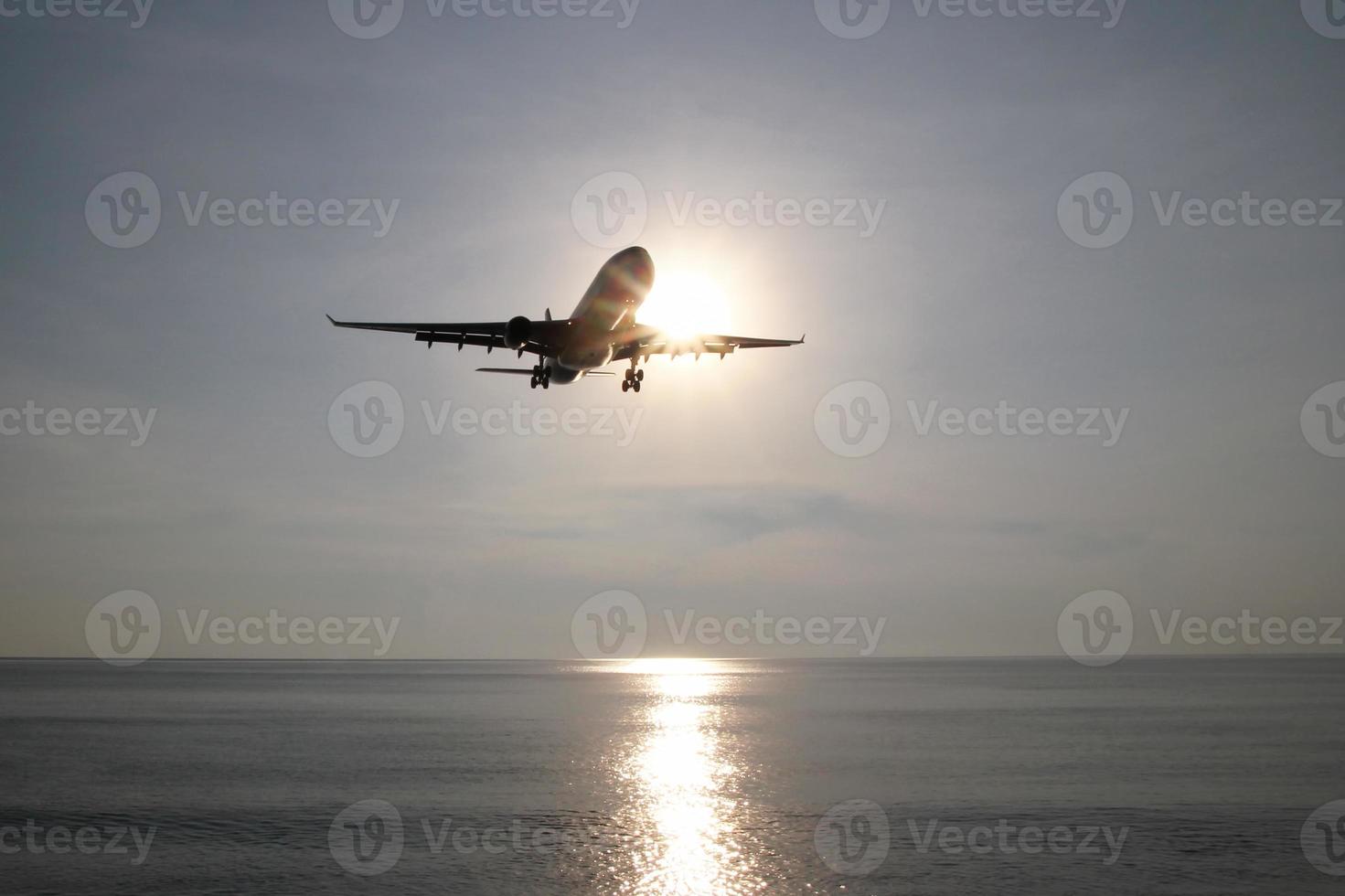 The view on a sea with plane in a sky in a sunny weather. Phuket, Thailand. photo